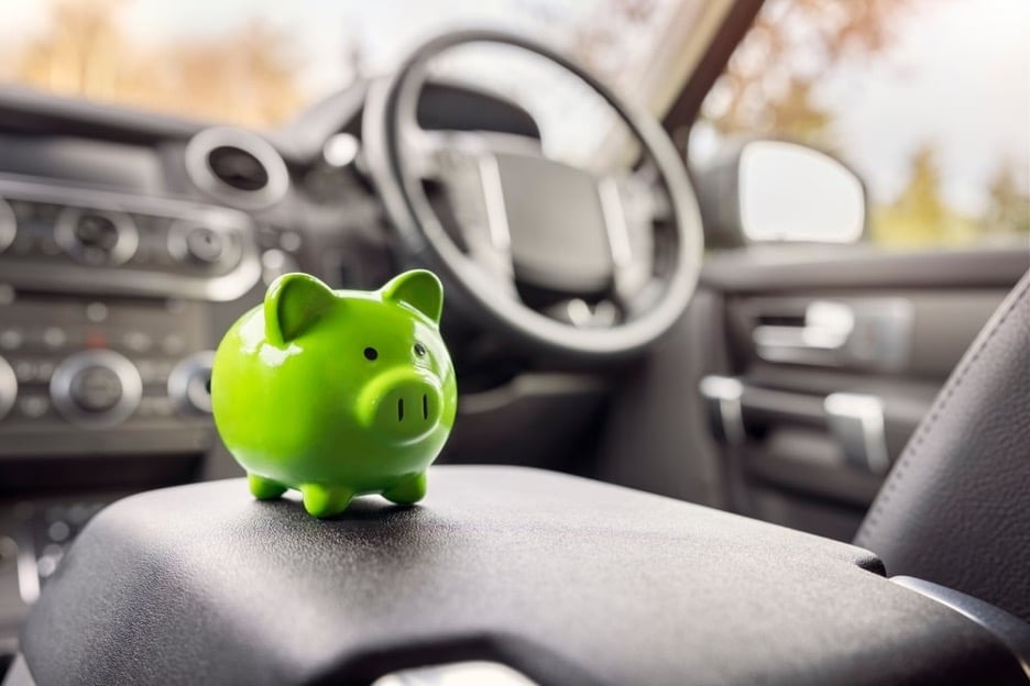 Groen varkensspaarpotje op armleuning in auto