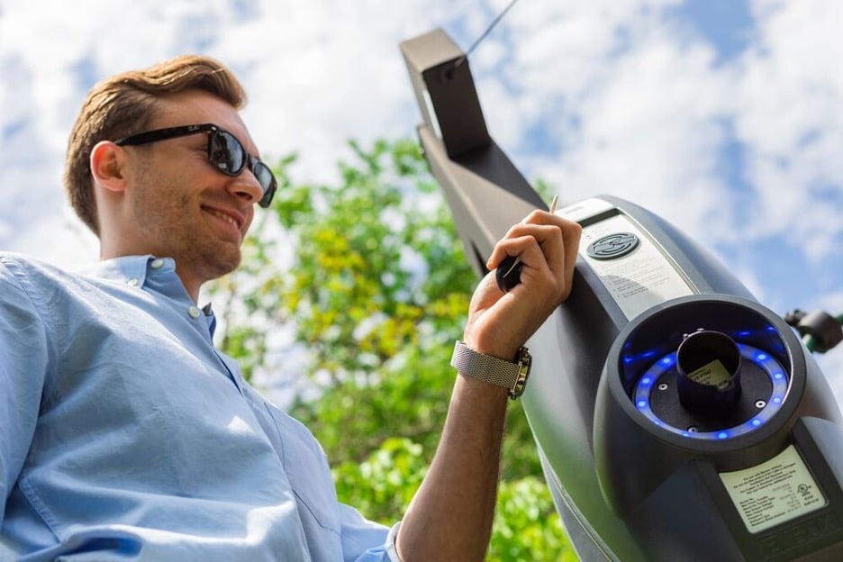 Man lacht terwijl hij RFID kaart laat lezen door laadstation