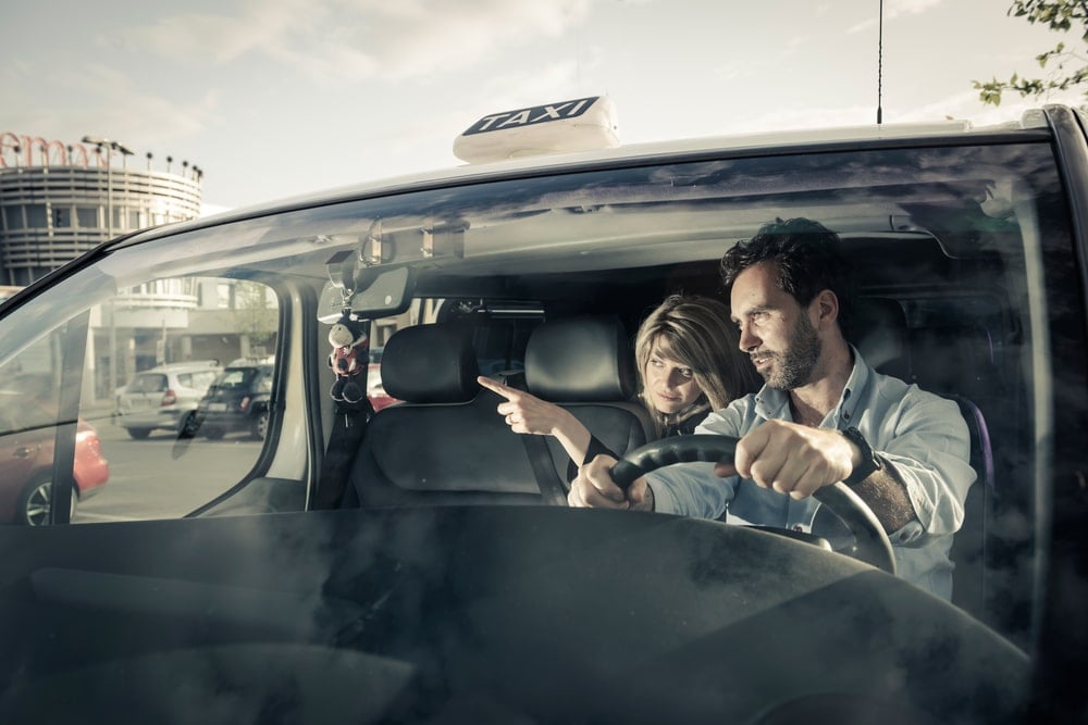 A taxi driver listening to directions from his passenger.