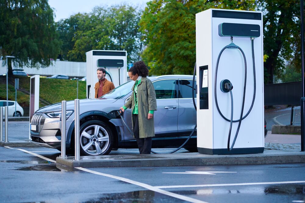 A couple charging their electric car with an EVBox Troniq Modular fast charger.