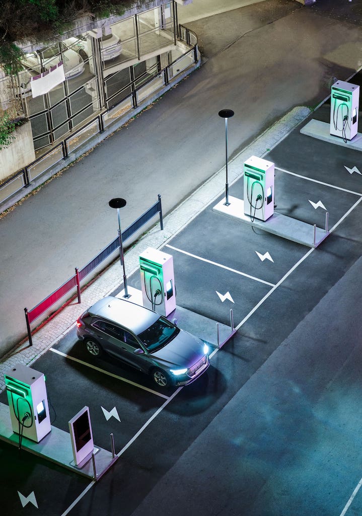 An electric car charging at an EVBox Troniq Modular DC fast charging station at night.