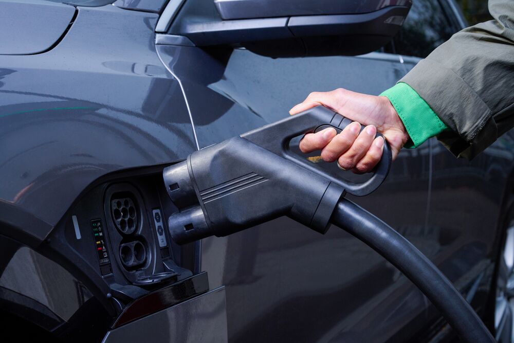 Someone plugging in their car to fast-charge an electric car.