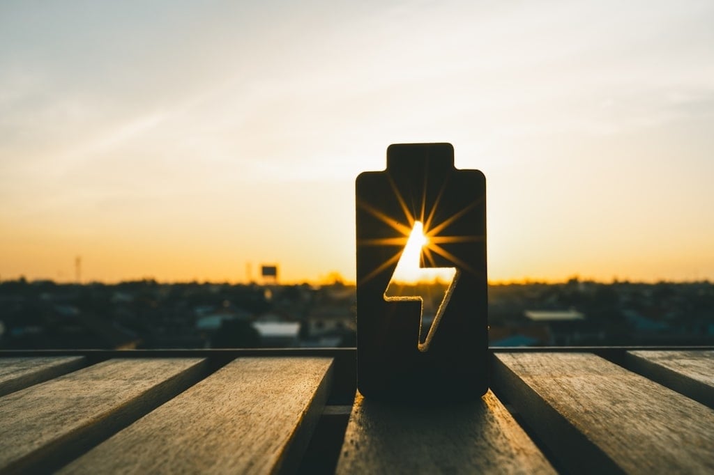 A battery visual getting charged by the sun to represent battery storage systems in combination with solar power.