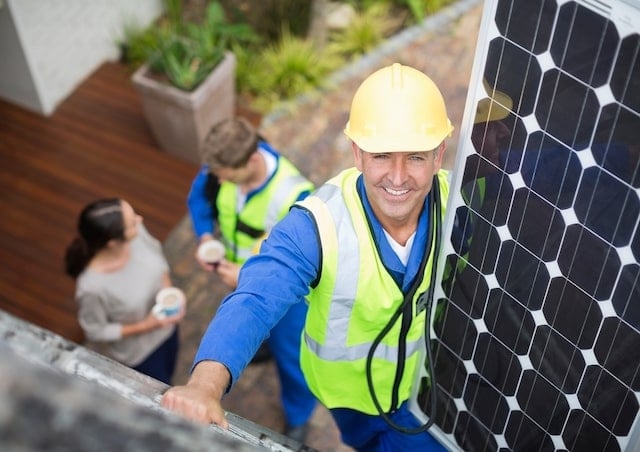 A professional is installing solar panels on a roof.