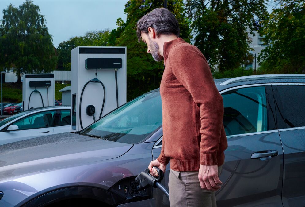 A man using an EVBox Troniq Modular Level 3 EV charging station.