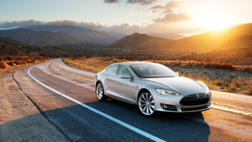 A Tesla driving on the road.