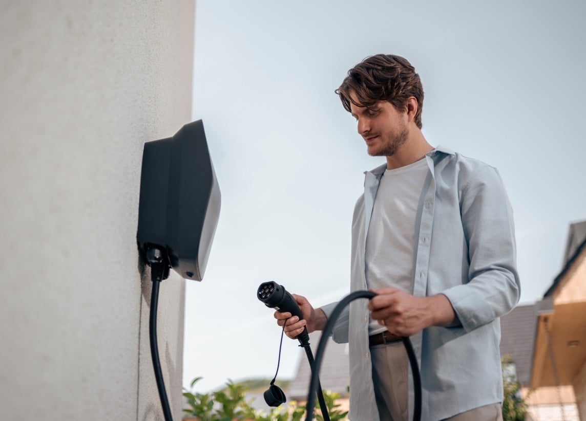 A man using his EVBox Livo Level 2 charging station at home.