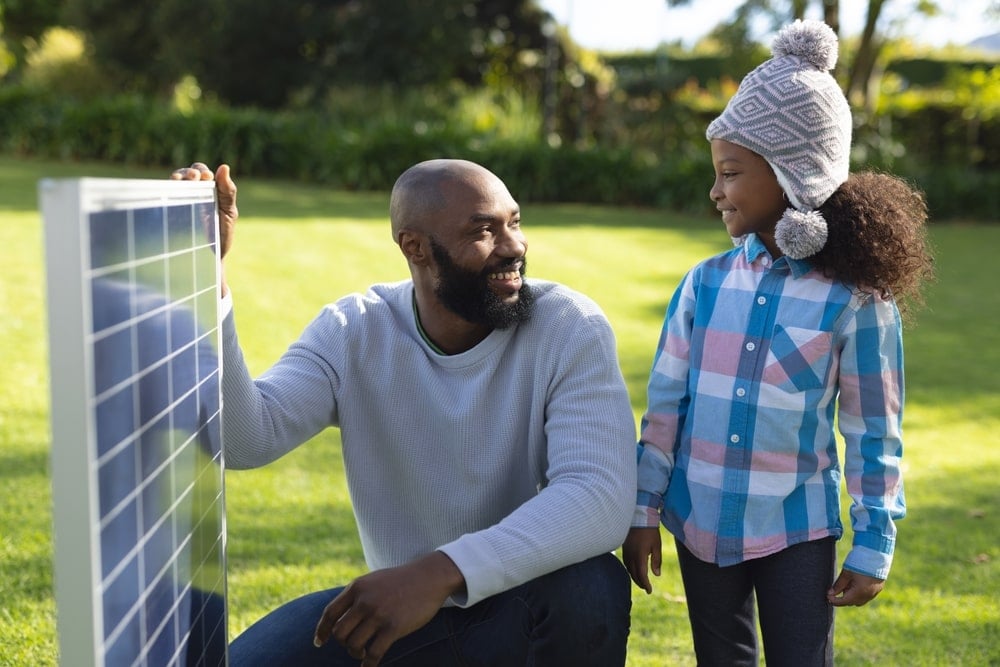 A father showing a solar panel to his daughter.