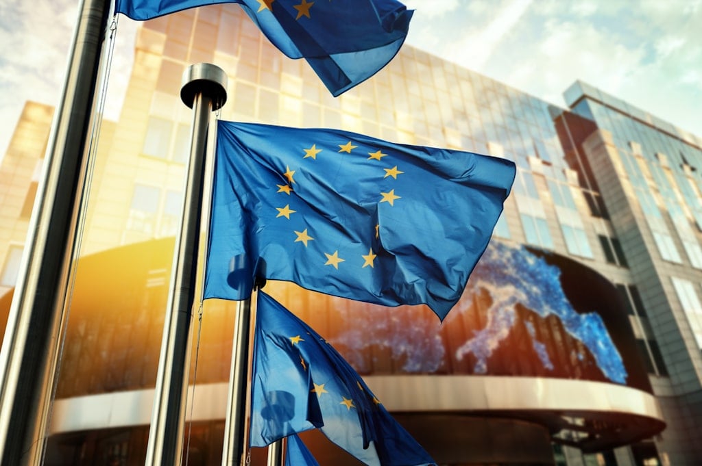 EU flags waving in front of the European Parliament building in Brussels, Belgium.