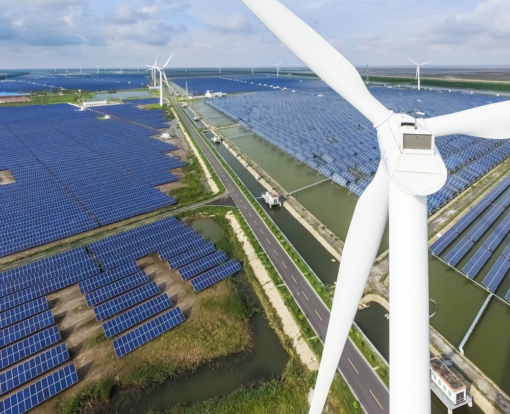 An areal view of windmills and solar panel farms.