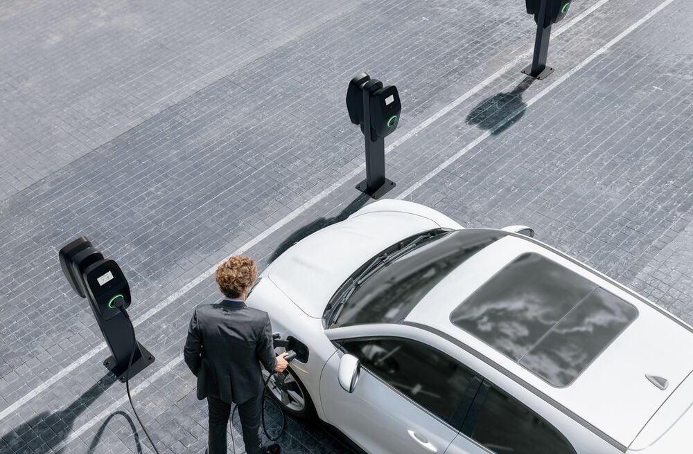 An employee charging his electric car at the workplace with an EVBox Liviqo charging station.