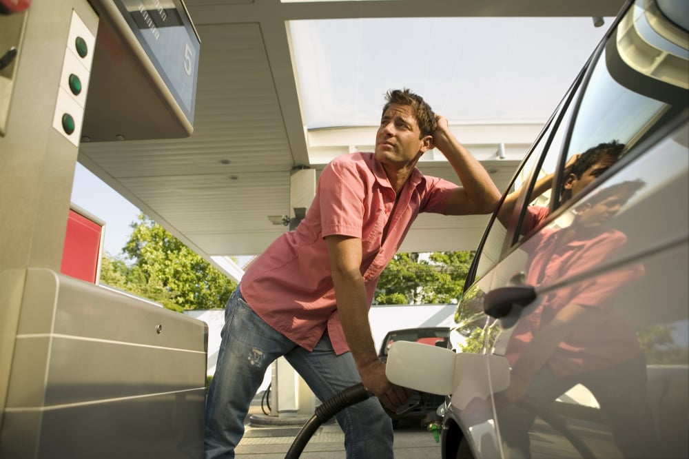 Man pumping gas into car.